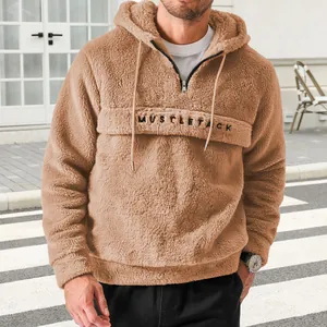 Close-up of men's fuzzy teddy fleece hoodie with half-zip and letter embroidery