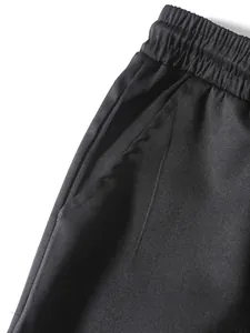 Close-up detail showing the elastic waistband and side pocket on black retro cargo pants