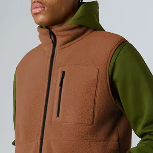 Close-up of a brown fleece outdoor vest with a stand collar and vertical zip pocket