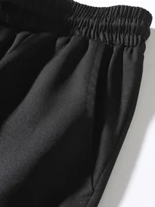 Close-up detail showing the elastic waistband and pocket stitching on black cargo joggers