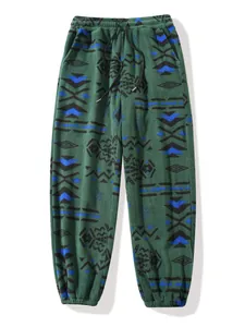 Detailed view of green fleece joggers with ethnic geometric patterns and drawstring waist
