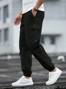 Detail of men's black high street cargo joggers with pocket tag and elastic cuff