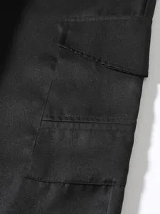 Macro detail of black cargo pant pocket showing durable twill fabric and stitching.