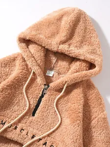 Close-up of brown plush fleece hoodie featuring embroidery and drawstring detail