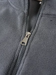 Detailaufnahme des Metallreißverschlusses am grauen Fleece-Sweatshirt für Herren.