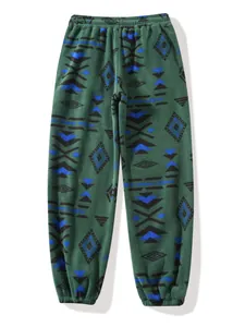 Detailed view of green fleece joggers featuring blue and black geometric tribal patterns