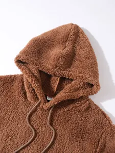 Detailed macro view of soft brown teddy fleece texture on a casual hooded sweatshirt