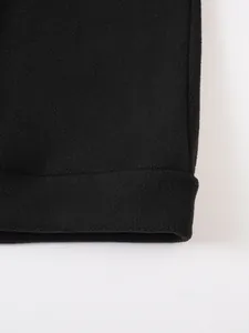 Detailaufnahme der weichen Textur des schwarzen Korallenvlies-Saums einer Herrenjacke