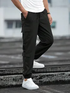 Detailed view of men's black high street retro cargo joggers featuring side flap pockets