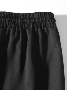 Detail view of the elastic waistband on men's black heavyweight twill cargo pants