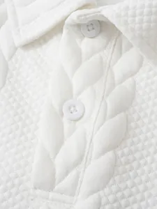 Macrodetail van witte jacquard getextureerde stof en knopen op een casual poloshirt voor heren