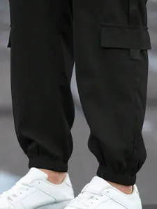 Detailed macro view of black men's cargo joggers with elastic ankle cuffs and pockets.