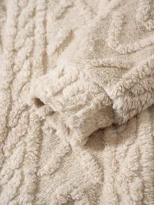 Κοντινό πλάνο από κρεμ ανάγλυφο ύφασμα fleece με σχέδιο στο μανίκι της φούτερ