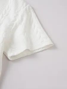 Close-up van de witte jacquard gebreide stof van een heren casual top met korte mouwen