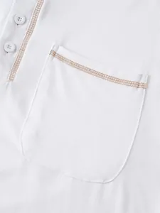 Détail des surpiqûres contrastées sur un polo à manches longues en coton blanc pour homme