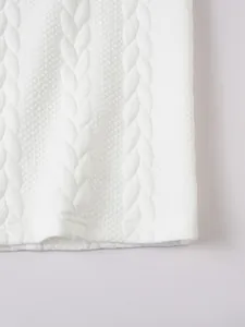 Macro detail of white cable knit jacquard pattern on a men's solid polo shirt.