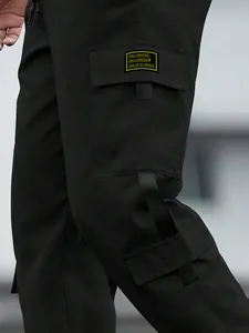 Close-up of black men's high-street cargo pants with pocket and graphic patch detail