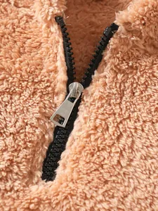 Detailed close-up of brown sherpa fleece texture and a sturdy black plastic zipper