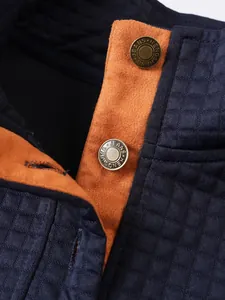 Primer plano de botones de latón vintage en una sudadera de hombre azul marino con cuello alto