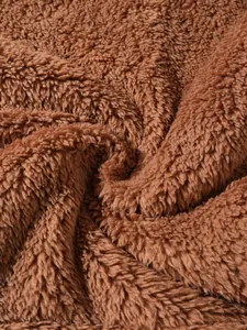 Detailed close-up showing the soft and warm brown sherpa fleece fabric texture of a men's hoodie.
