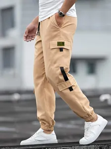 Close-up side view of men's vintage khaki cargo joggers with functional flap pockets
