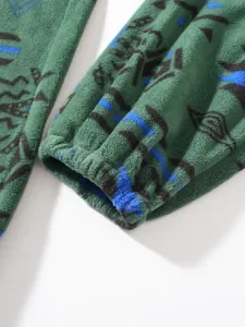 Macro view of green fleece garment cuff featuring elastic ribbing and tribal pattern