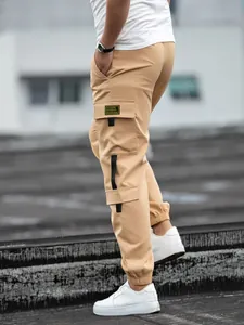 Close-up detail of side cargo pocket and black strap accents on khaki joggers
