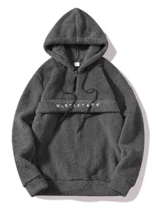 Close-up detail of a grey teddy fleece hoodie with a half-zip and chest embroidery.