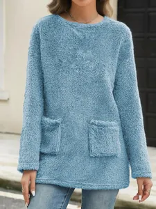 Close-up detail of women's blue fuzzy long-sleeve sweatshirt with cozy front pockets