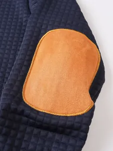 Primer plano de la codera de ante marrón claro en sudadera acolchada azul marino