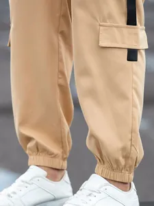 Detailed macro view of men's camel cargo jogger pants with elastic cuffs and side pocket