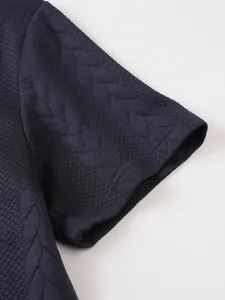 Detailopname van de getextureerde jacquardstof van een donkerblauw herenpoloshirt