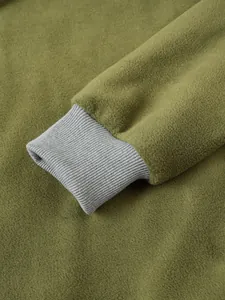 Detailansicht des gerippten Bündchens und des weichen Polarfleece am grünen Sweatshirt