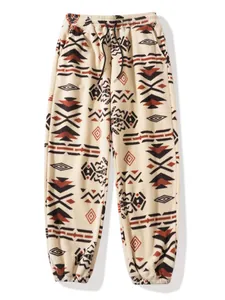 Detailed view of the ethnic geometric pattern on warm cream fleece jogger pants