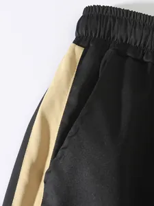 Detail of men's cargo pants showing elastic waistband and beige side stripe texture