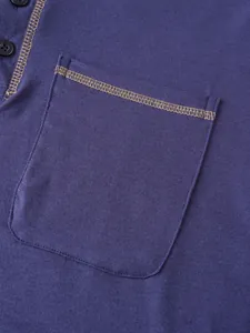 Gros plan de la poche poitrine avec coutures contrastées sur un polo bleu marine