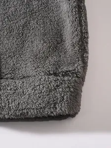Close-up detail of soft dark grey plush fleece fabric for a men's winter jacket hem
