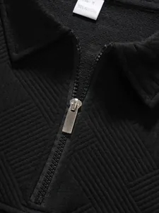 Detailaufnahme des strukturierten schwarzen Polo-Kragens mit Metallreißverschluss