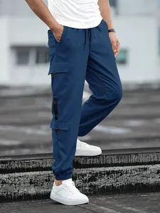 Close-up detail of men's navy blue cargo jogger pants with functional utility side pockets
