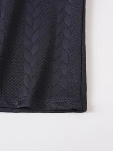 Detailed close-up of navy blue jacquard cable-knit fabric and stitched hem of polo shirt