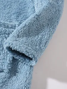 Detailed macro view showing the soft fuzzy texture of a blue plush sweatshirt sleeve.