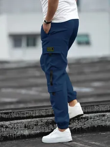 Close-up detail of navy blue men's cargo joggers featuring side utility pockets and patch