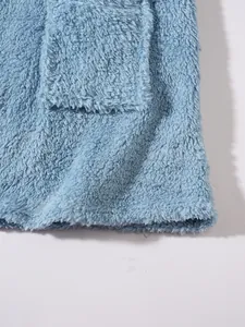 Close-up of blue plush fleece fabric texture and pocket detail on a casual sweatshirt