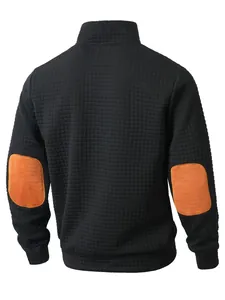 Vista trasera de sudadera negra para hombre con tejido de gofre, cuello alto y parches naranjas.
