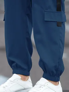 Close-up detail of blue men's high street cargo pants with elastic cuffs and pocket strap