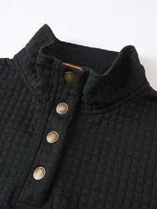 Primer plano de una sudadera acolchada negra para hombre con cuello alto y botones