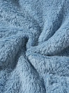 Macro detail of the soft and cozy light blue plush fleece fabric texture for winter sweatshirt
