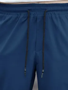 Close-up detail of elastic waistband and drawstrings on navy blue men's jogger pants.