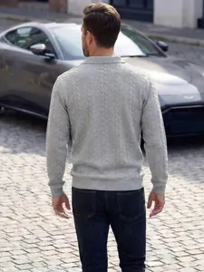 Rückenansicht eines hellgrauen Zopfstrick-Poloshirts für Herren in städtischer Umgebung.
