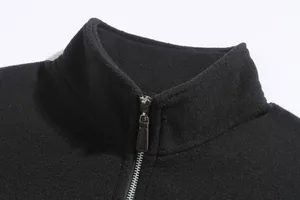 Detalle de chaqueta de forro polar negra con cuello alto y cremallera metálica.